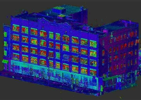 A 3D point cloud rendering of a multi-story building with various colors representing different elevations or data points, akin to intricate 3D printing. The dark background makes the building details stand out vividly.