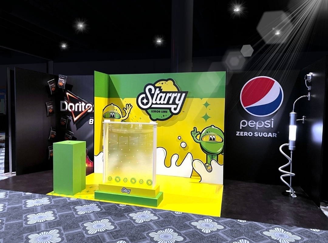 Image of a promotional booth for Starry Lemon Lime, Doritos, and Pepsi Zero Sugar featuring branded graphics produced using small format printing and a green podium.