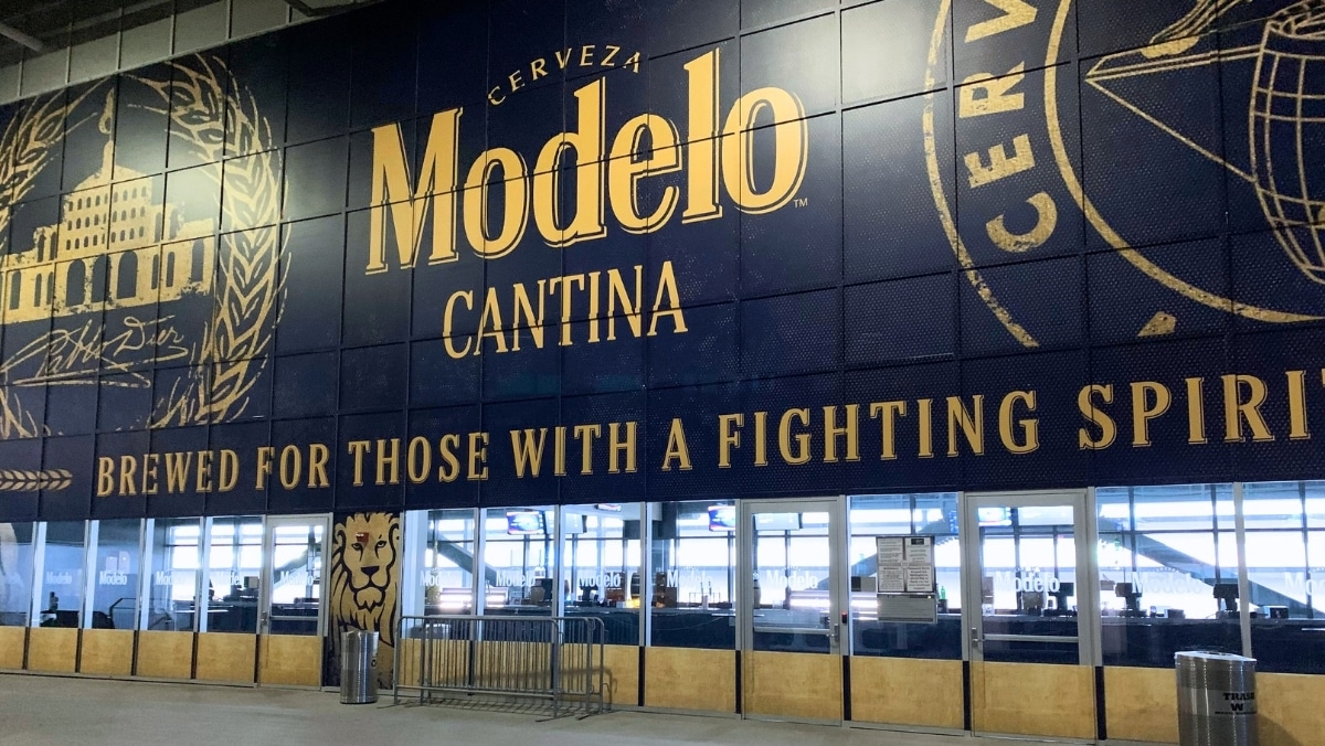 Large advertisement for Modelo Cantina beer with the slogan "Brewed for Those with a Fighting Spirit" displayed on a wall outside a venue, showcasing the impressive capability of large format printing.