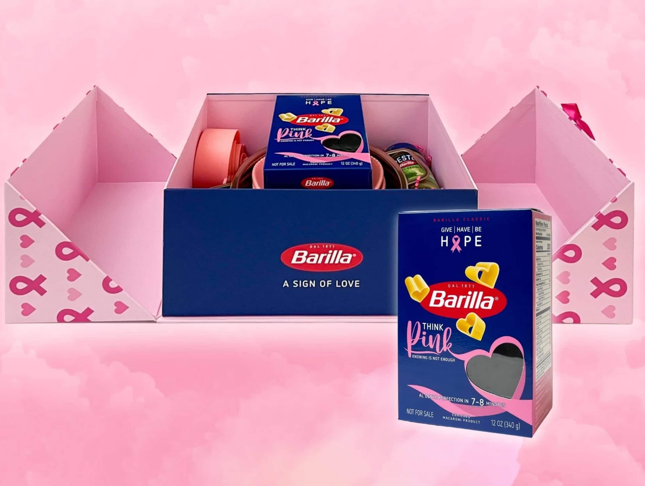 Box of Barilla pasta with themed packaging on a pink background. Opened gift box with more pasta packages and a pink ribbon design, symbolizing breast cancer awareness. The small format printing on the packaging enhances its delicate and meaningful presentation.