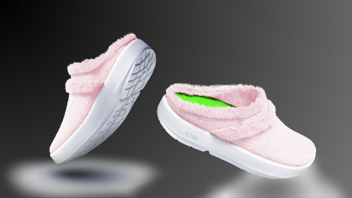 Two pink fuzzy slippers with white soles appear as if they're floating, crafted to perfection with 3D scanning services, against a gradient gray background.