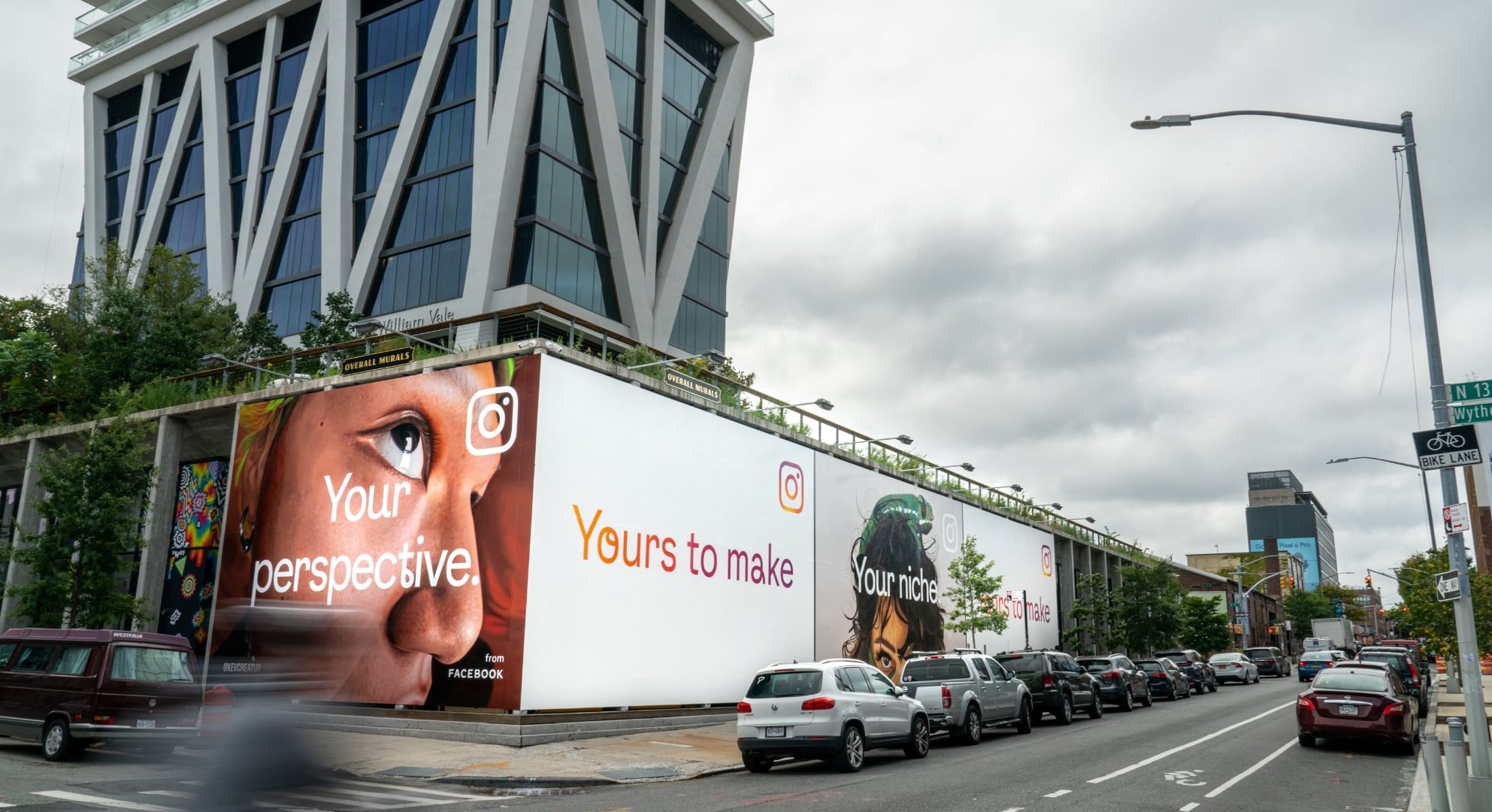 Urban street with modern buildings and a large billboard featuring Instagram advertisements, showcasing various photos and captions like "Your perspective." and "Yours to make." The vibrant visuals demonstrate the power of large format printing in bringing digital experiences to life.