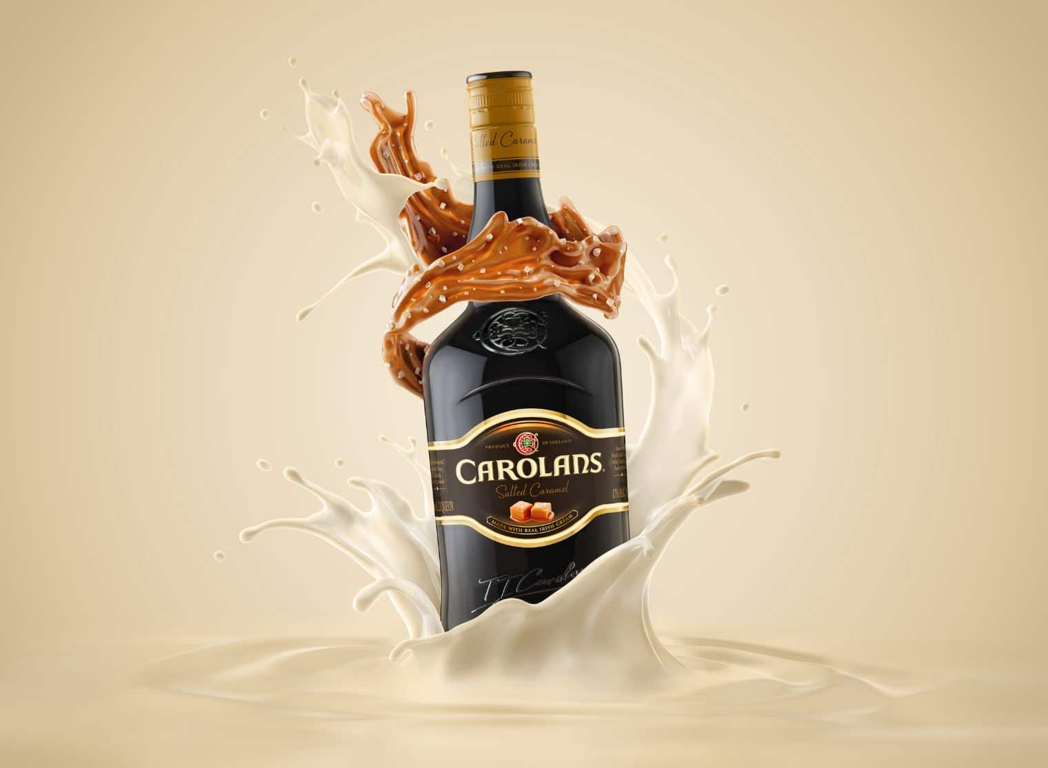 A bottle of Carolans Salted Caramel Irish Cream Liqueur being splashed by milk, set against a beige background.